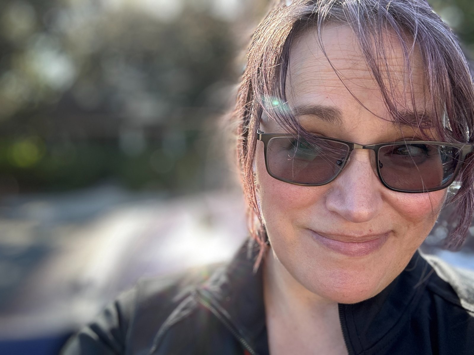 Lani smiling outdoors in sunglasses
